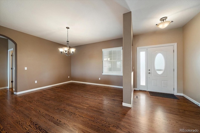 22873 E David Pl, Aurora, CO 80016 - foyer entrance with arched walkways, dark wood-style floors, and a chandelier