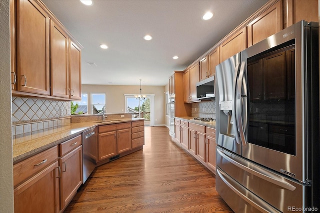 22873 E David Pl, Aurora, CO 80016 - kitchen featuring stainless steel appliances, recessed lighting, a peninsula, dark wood-type flooring, and backsplash
