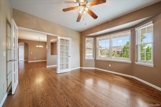 22873 E David Pl, Aurora, CO 80016 - empty room with arched walkways, french doors, wood finished floors, ceiling fan, and a chandelier