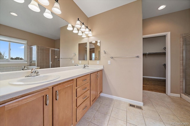22873 E David Pl, Aurora, CO 80016 - full bath featuring a stall shower, double vanity, a walk in closet, and tile patterned flooring