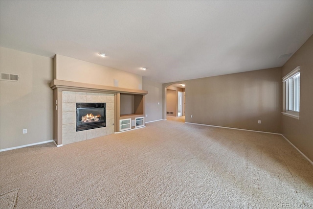 22873 E David Pl, Aurora, CO 80016 - unfurnished living room with arched walkways, a fireplace, and carpet flooring
