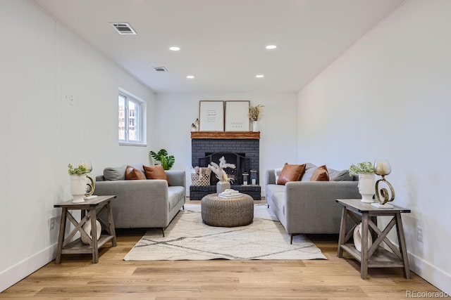 living room featuring light wood-type flooring and a fireplace