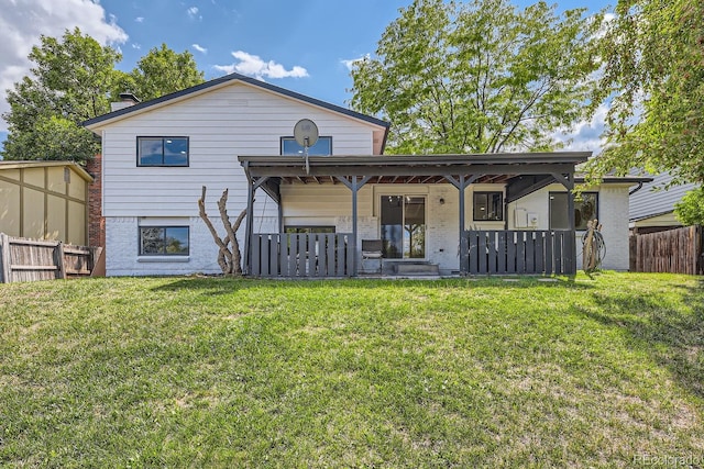 rear view of house with covered porch and a lawn