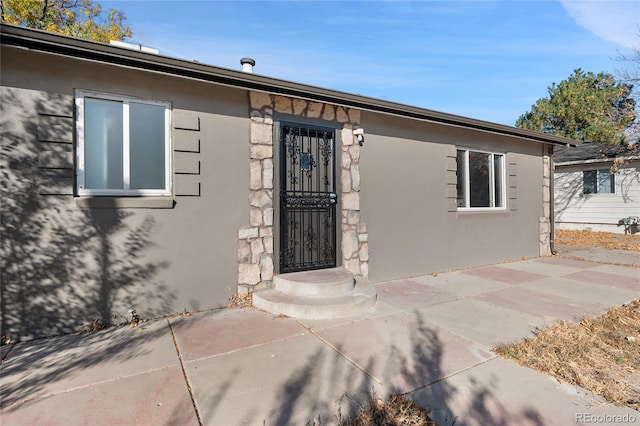 view of exterior entry with a patio area