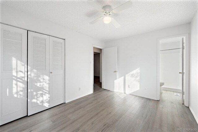 unfurnished bedroom with connected bathroom, ceiling fan, a textured ceiling, and light wood-type flooring