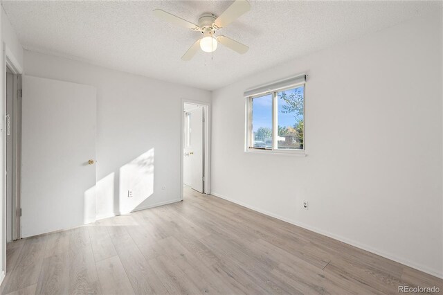 spare room featuring a textured ceiling, light hardwood / wood-style floors, and ceiling fan