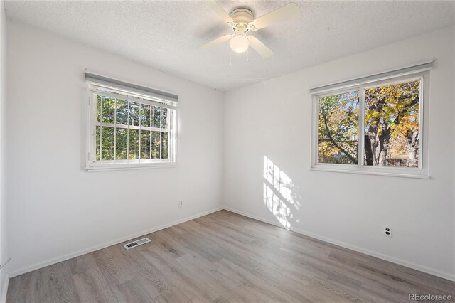 spare room with light hardwood / wood-style flooring, a textured ceiling, and ceiling fan