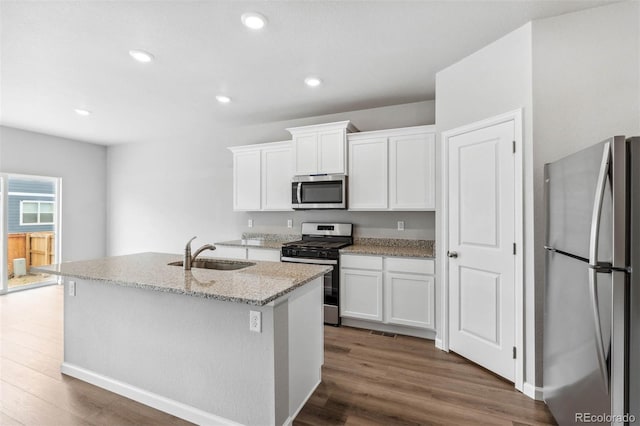 kitchen featuring white cabinets, appliances with stainless steel finishes, a center island with sink, and sink