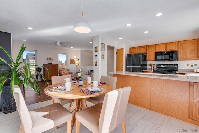 dining space featuring a ceiling fan, recessed lighting, light wood-type flooring, and a textured ceiling