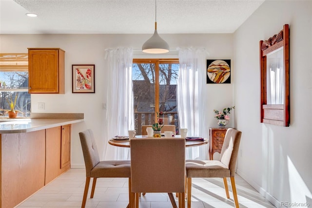 dining room with baseboards, a textured ceiling, and recessed lighting