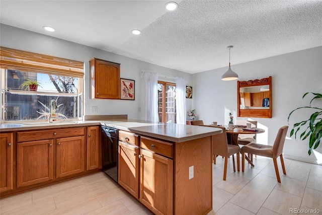 kitchen with dishwasher, hanging light fixtures, a peninsula, and brown cabinets