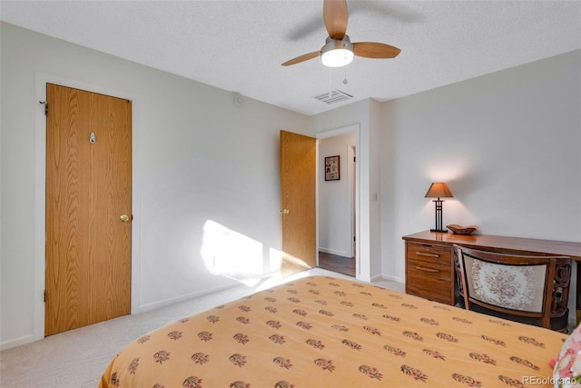 bedroom featuring light colored carpet, visible vents, ceiling fan, a textured ceiling, and baseboards