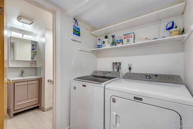 laundry area with laundry area, washer and clothes dryer, and a sink