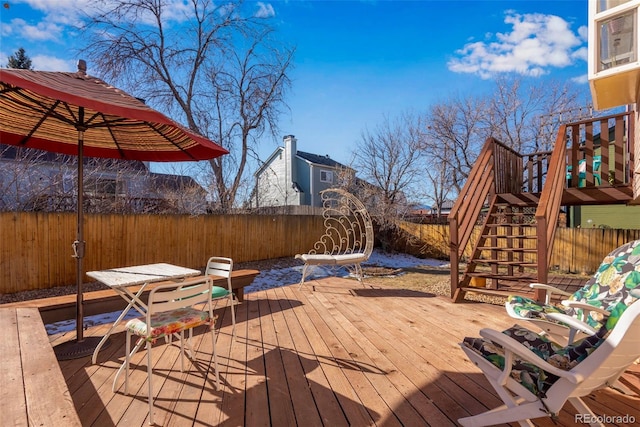 wooden deck featuring a fenced backyard and stairs