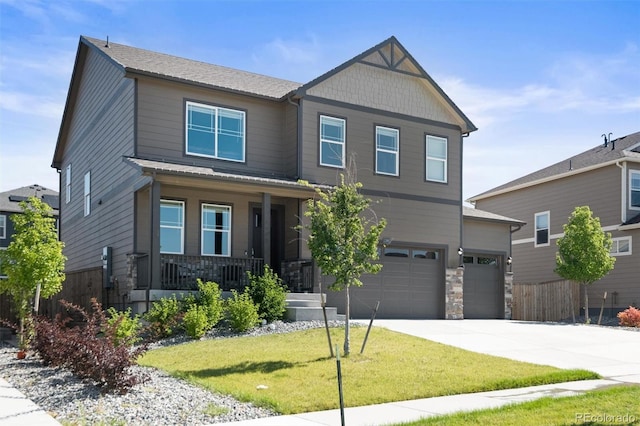 craftsman inspired home with covered porch, a garage, stone siding, driveway, and a front yard