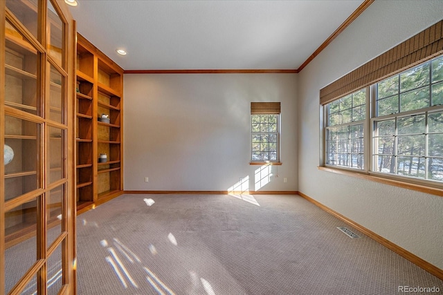 unfurnished room with crown molding and carpet floors