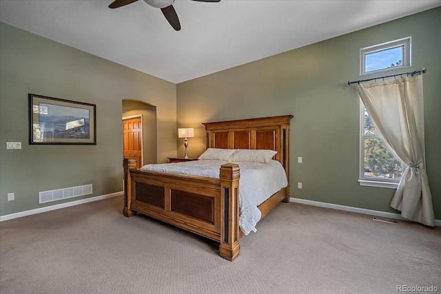 carpeted bedroom featuring multiple windows, lofted ceiling, and ceiling fan