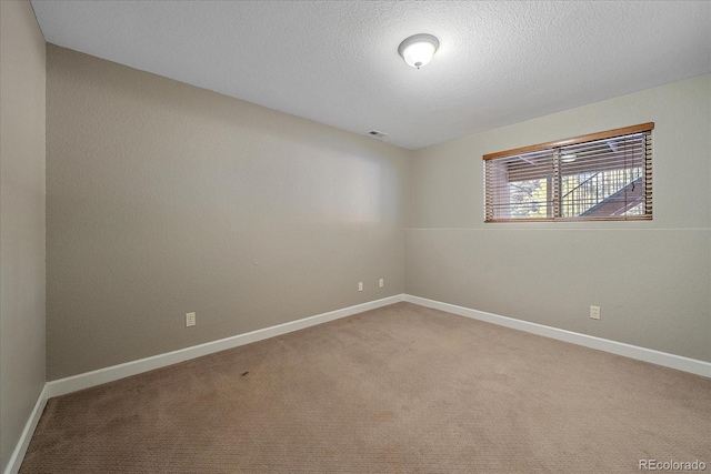 empty room with carpet and a textured ceiling