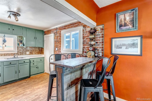 3151 N Elizabeth St, Denver, CO 80205 - kitchen with green cabinets, light wood-style floors, light countertops, and tasteful backsplash