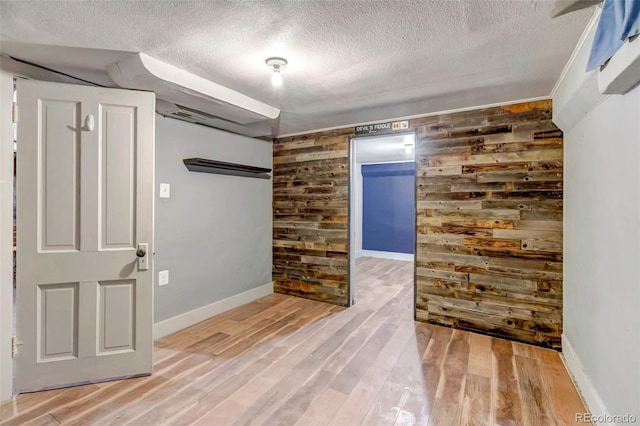 3151 N Elizabeth St, Denver, CO 80205 - spare room featuring a textured ceiling, wood walls, light wood-style floors, and an accent wall