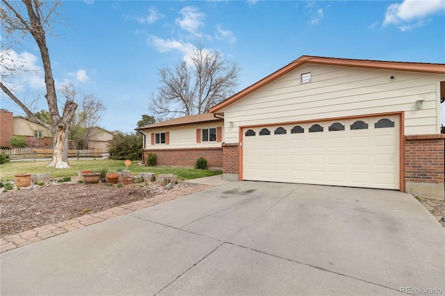 single story home with brick siding, concrete driveway, and fence
