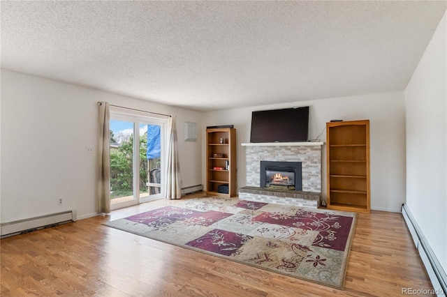 living area with a baseboard heating unit, baseboard heating, wood finished floors, and a textured ceiling