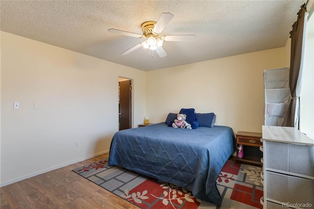 bedroom with wood finished floors, a ceiling fan, and a textured ceiling