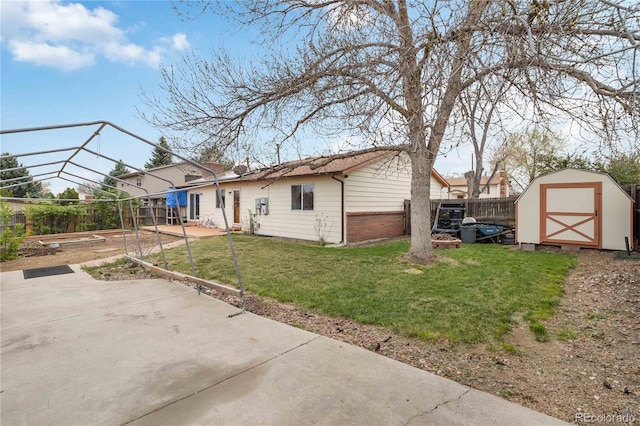 back of house featuring a patio, a storage shed, brick siding, and an outbuilding