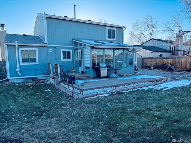 rear view of property with a lawn, a wooden deck, and a sunroom