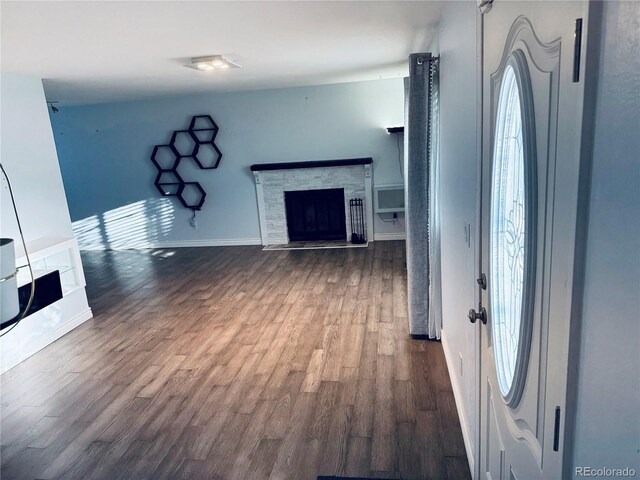 unfurnished living room with a fireplace, hardwood / wood-style flooring, and a healthy amount of sunlight