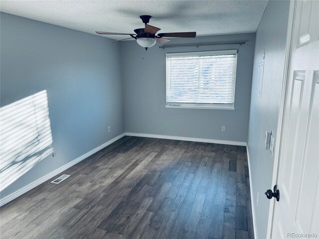 unfurnished room featuring a textured ceiling, dark hardwood / wood-style flooring, and ceiling fan