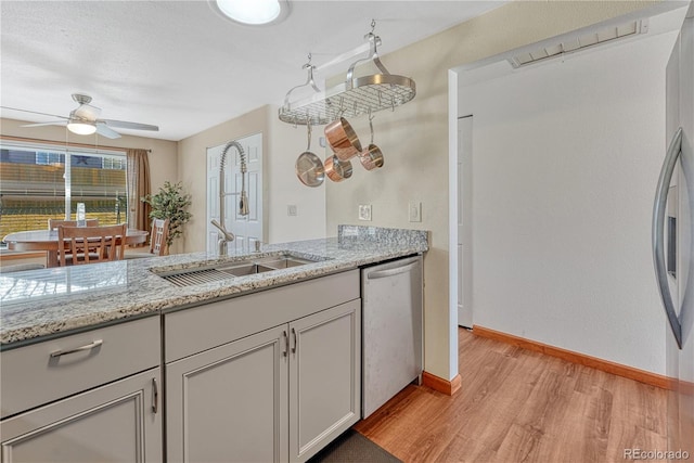 1786 Wintergreen Pl, Loveland, CO 80537 - kitchen featuring ceiling fan, a sink, baseboards, appliances with stainless steel finishes, and light wood finished floors