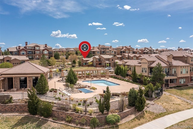 community pool featuring a residential view, fence, and a patio