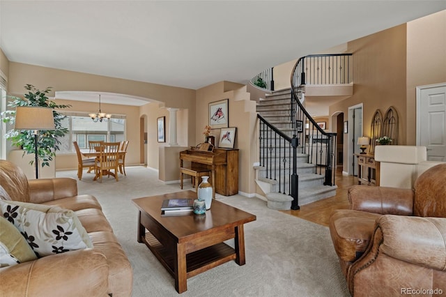 9249 Fox Fire Dr, Highlands Ranch, CO 80129 - living room with arched walkways, stairway, light carpet, and decorative columns