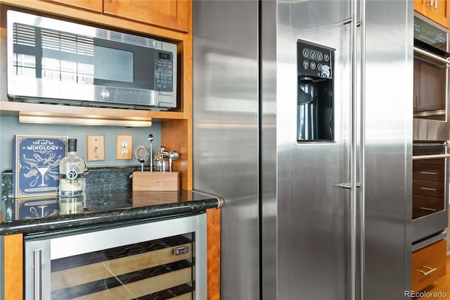 kitchen featuring dark stone countertops, wine cooler, and stainless steel appliances