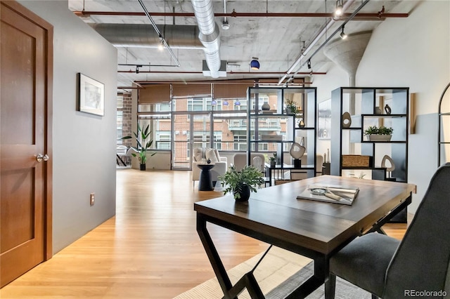 dining area with track lighting and light hardwood / wood-style flooring