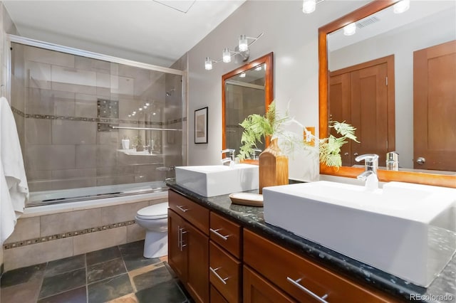 full bathroom featuring vanity, shower / bath combination with glass door, and toilet