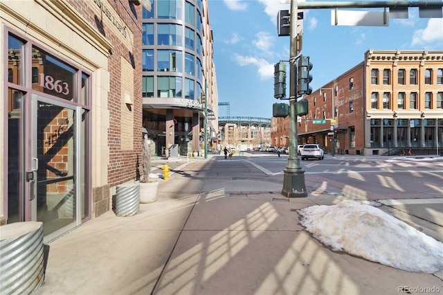 view of road with street lights, curbs, sidewalks, and traffic lights