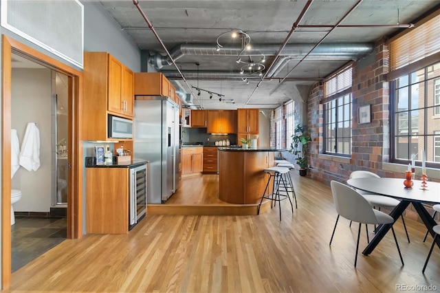1863 Wazee St Unit 6E, Denver, CO 80202 - kitchen with stainless steel refrigerator with ice dispenser, white microwave, light wood-style flooring, and dark countertops