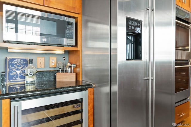 1863 Wazee St Unit 6E, Denver, CO 80202 - kitchen with appliances with stainless steel finishes, wine cooler, and dark stone countertops