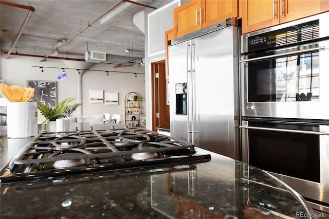 1863 Wazee St Unit 6E, Denver, CO 80202 - kitchen featuring stainless steel appliances, dark stone countertops, and brown cabinets