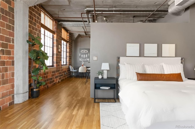 1863 Wazee St Unit 6E, Denver, CO 80202 - bedroom featuring wood finished floors and brick wall