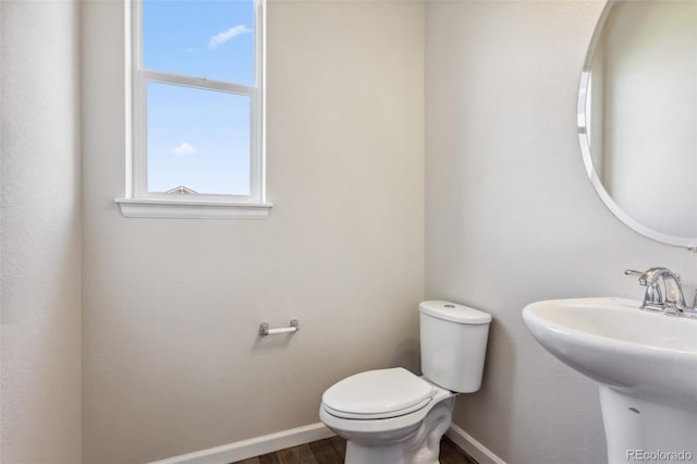 3823 Horiuchi St, Brighton, CO 80601 - bathroom featuring toilet, baseboards, wood finished floors, and a sink