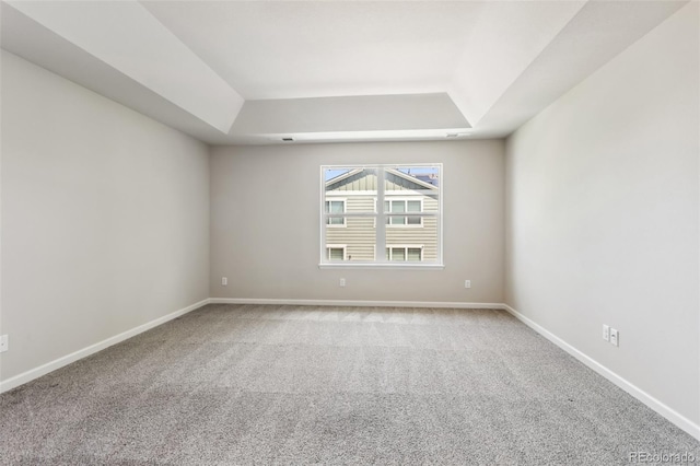 3823 Horiuchi St, Brighton, CO 80601 - spare room featuring a tray ceiling, light carpet, and baseboards