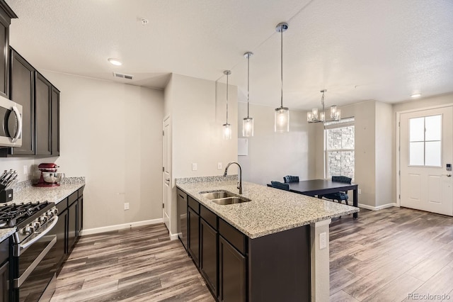 23545 E Platte Dr Unit C, Aurora, CO 80016 - kitchen featuring a sink, stainless steel appliances, baseboards, wood finished floors, and a textured ceiling
