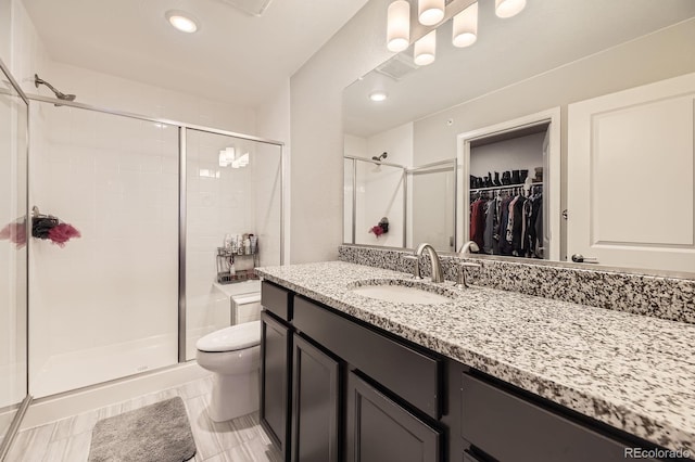 23545 E Platte Dr Unit C, Aurora, CO 80016 - full bathroom featuring toilet, a stall shower, a walk in closet, and vanity