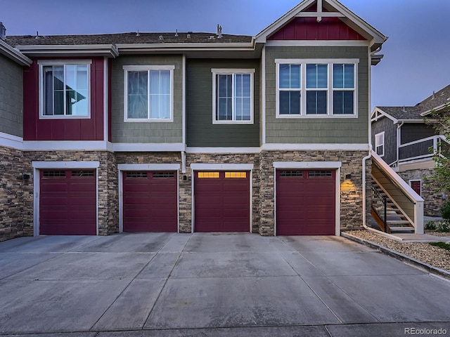 23545 E Platte Dr Unit C, Aurora, CO 80016 - view of property with driveway, an attached garage, stone siding, and board and batten siding