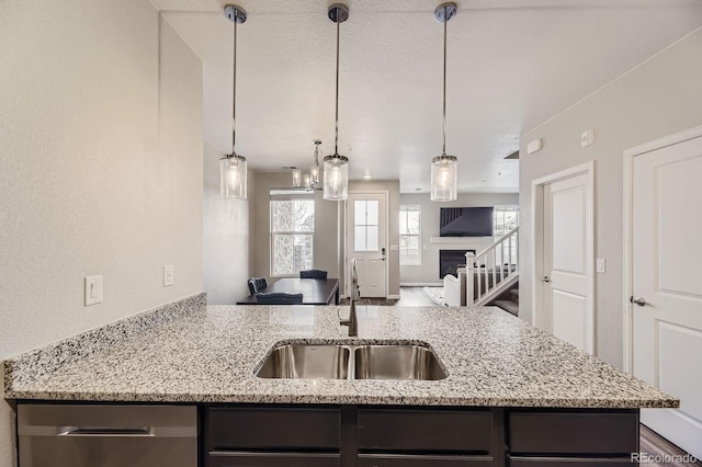 23545 E Platte Dr Unit C, Aurora, CO 80016 - kitchen featuring a sink, open floor plan, light stone countertops, decorative light fixtures, and stainless steel dishwasher