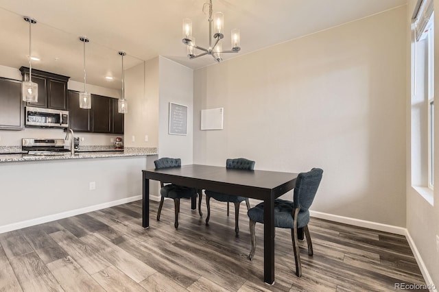 23545 E Platte Dr Unit C, Aurora, CO 80016 - dining area featuring a chandelier, dark wood-style flooring, and baseboards