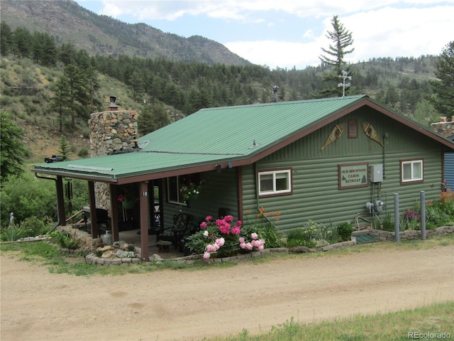 57920 US Highway 285 Unit 10, Bailey, CO 80421 - view of property exterior with a chimney, a mountain view, a forest view, and a metal roof
